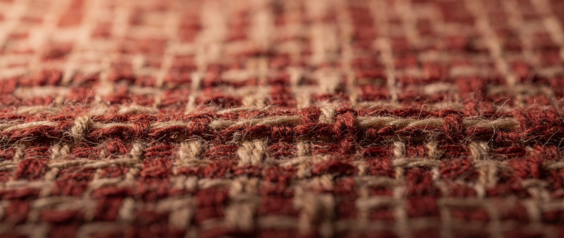 Close view of a red and cream cotton check with thick crossing yarns.