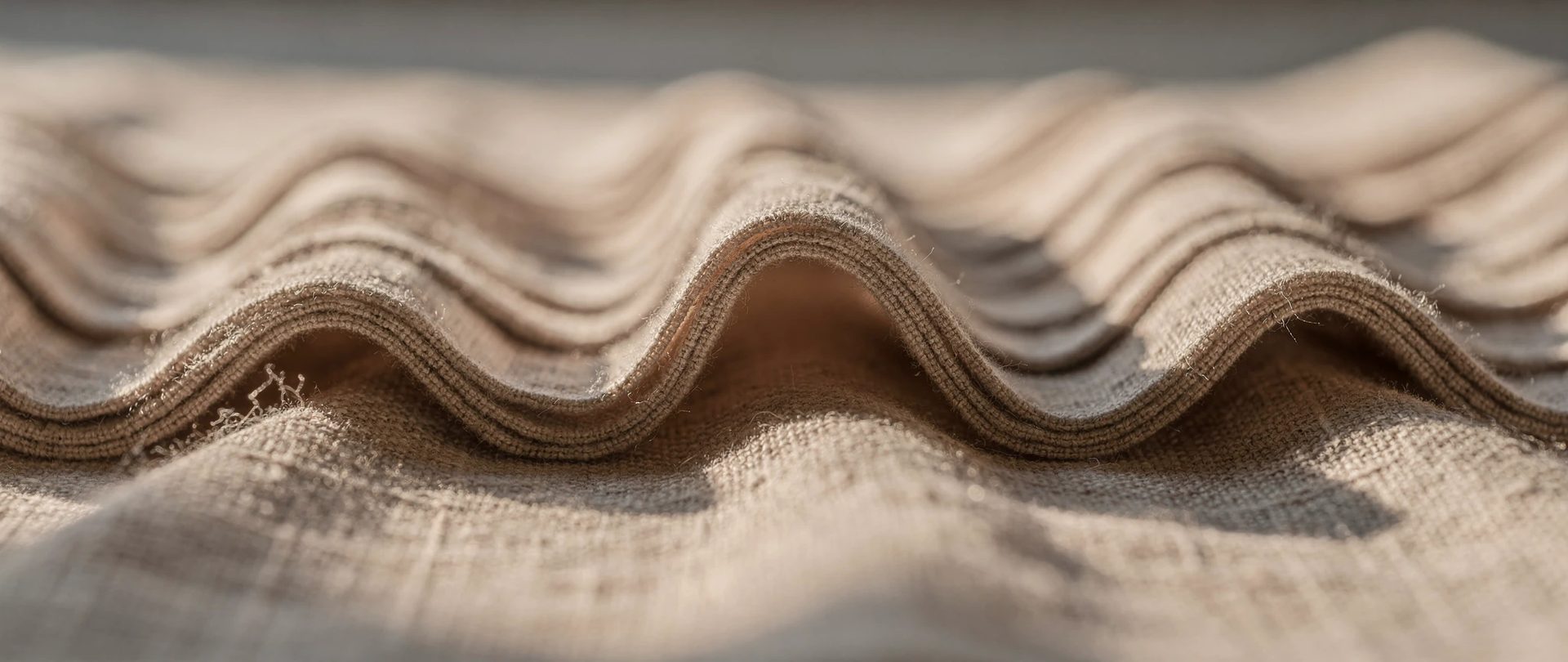 Continuous S-shaped waves in soft beige linen, each curve repeating with even rhythm.