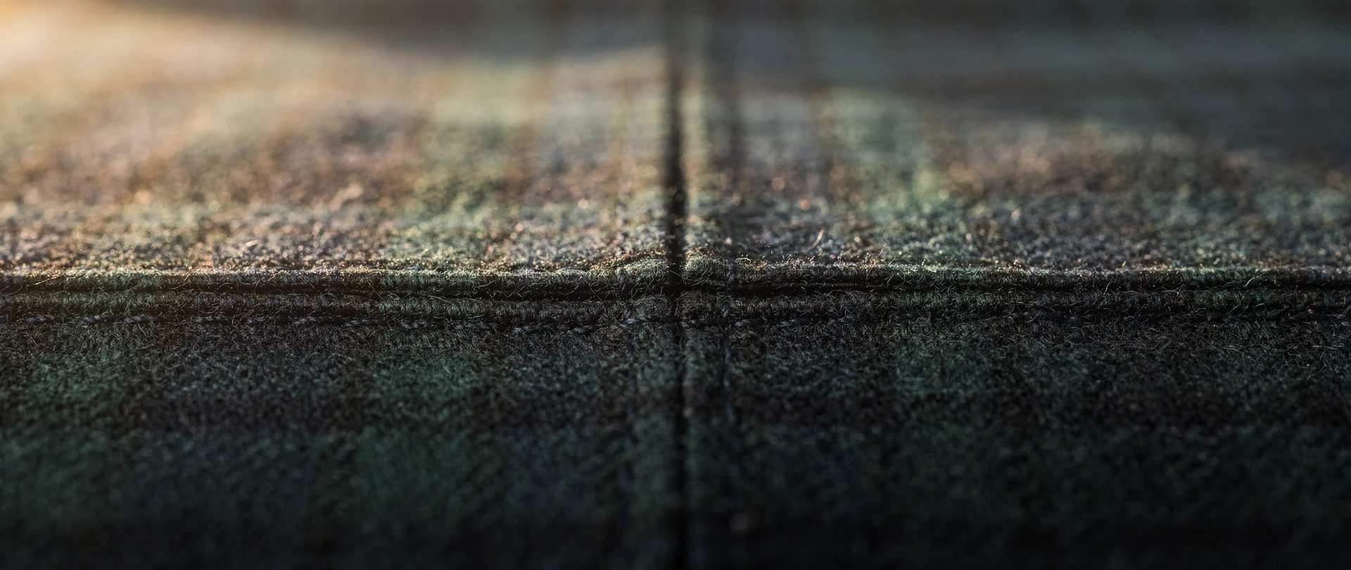 Couture dans un tartan de laine vert forêt et marine, où les lignes se rejoignent de chaque côté.